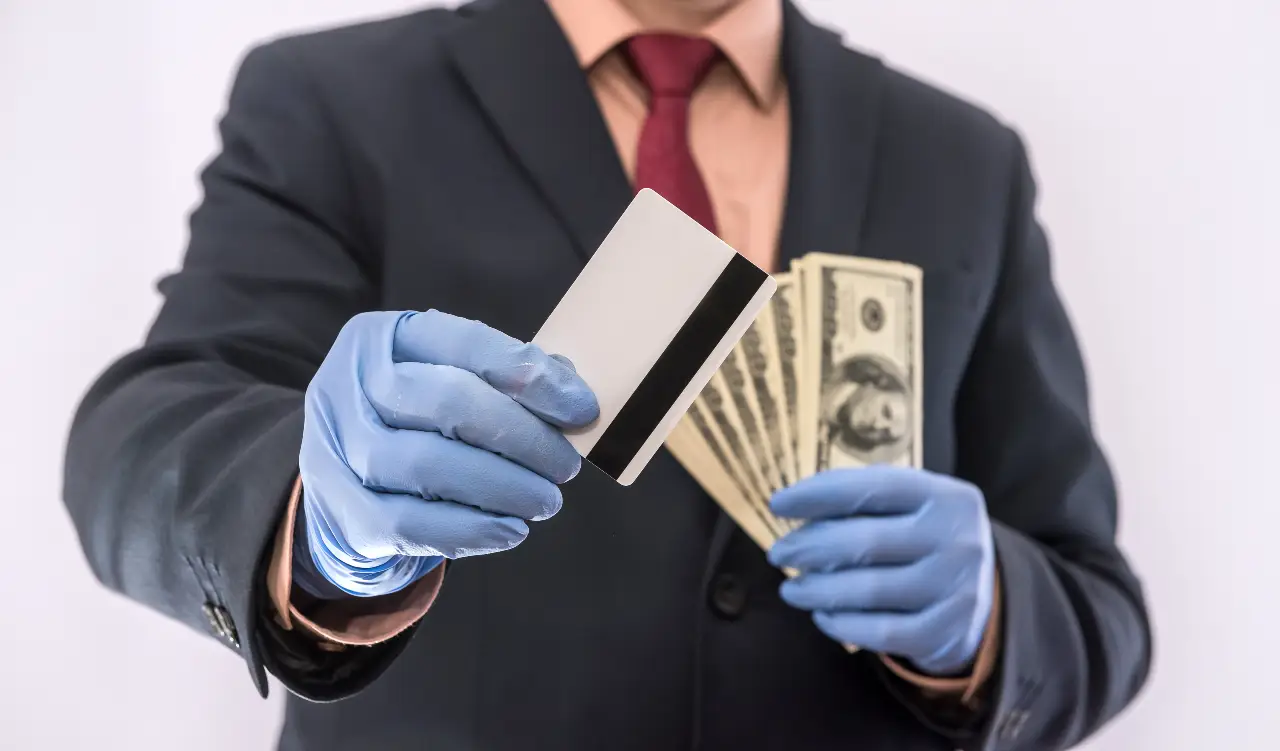 Ilustración de un hombre con guantes que sostiene tarjeta de plástico y unos billetes de dólares